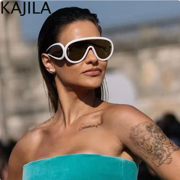 Headshot of a girl standing in what looks like to be a tourist area, wearing a sleeveless green dress and a pair of White & Brown Oversized Punk UV400 Sunglasses Color 2 
